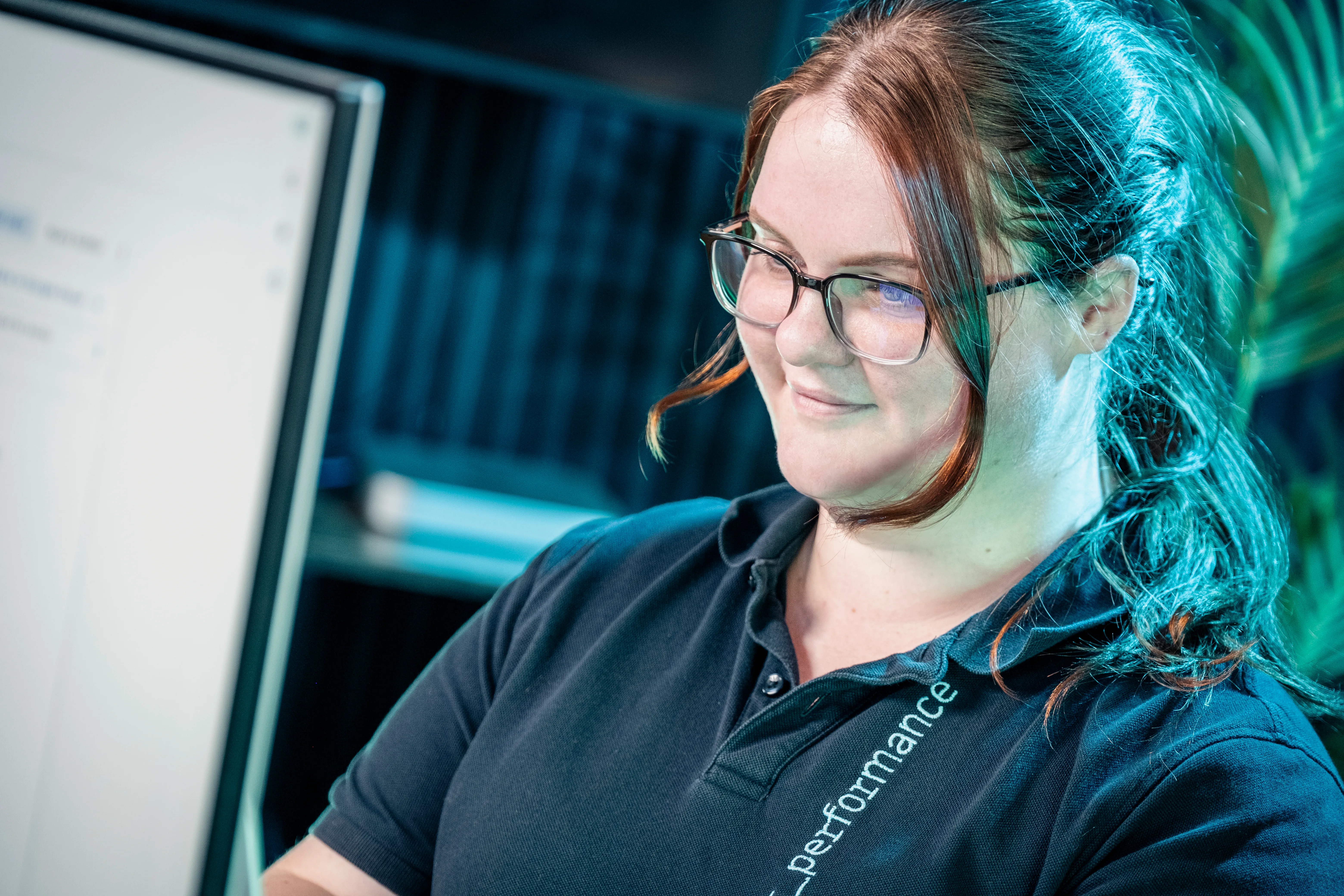 Paula, accounts executive at dot performance isle of man, working on laptop whilst smiling